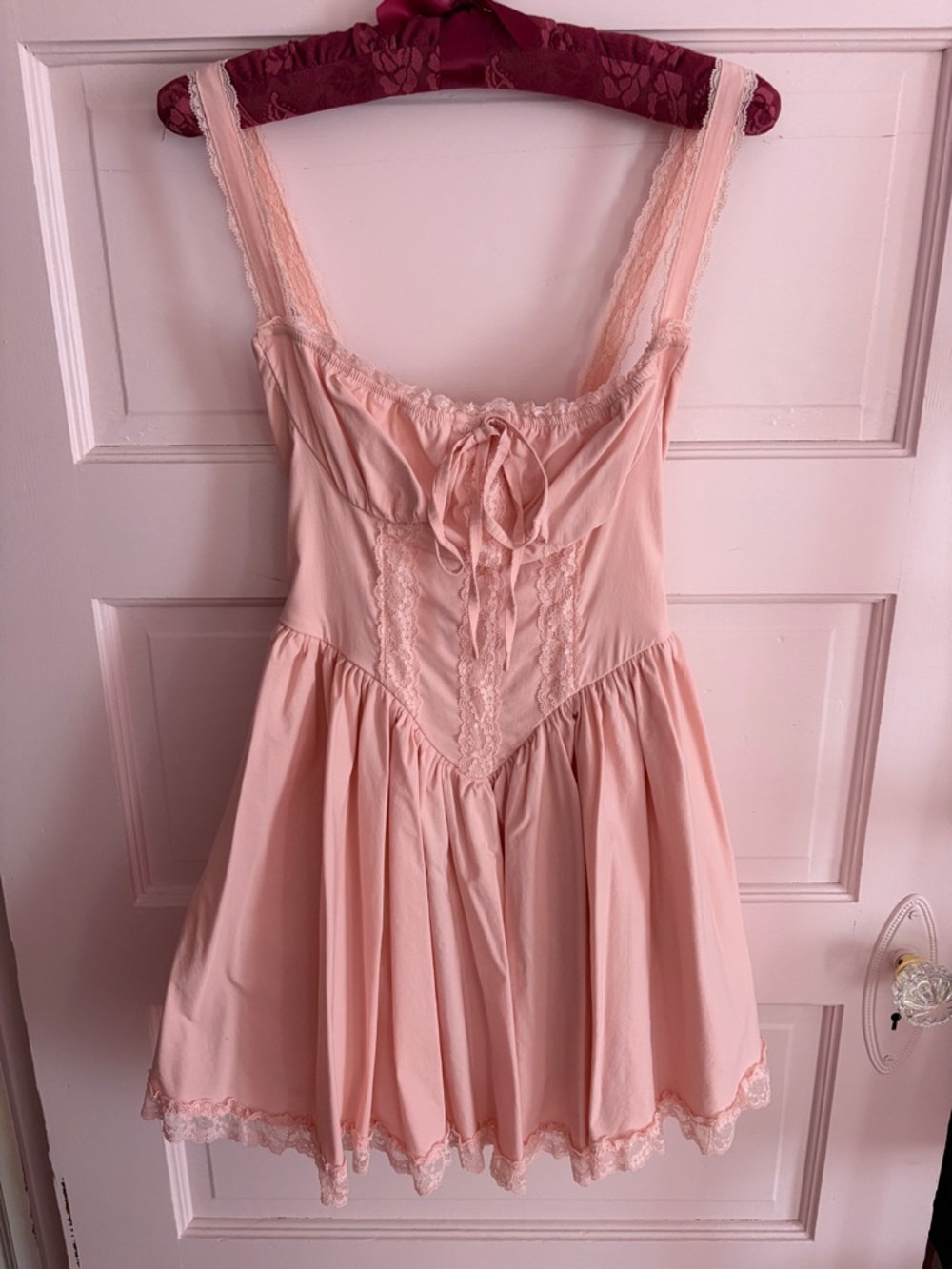 Soft pink mini babydoll Glinda dress with lace details bow in middle